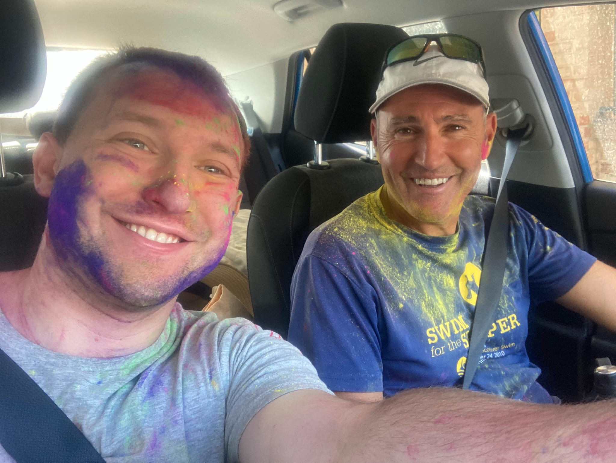 The father-and-son writing team behind the pen name TJ Feldman, covered in colour-run paint after a community fun run